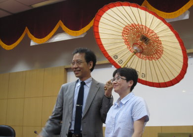歷史系助理教授廖敏淑(右)致贈唐啟華紙傘,歡迎他常常回到多雨政大。攝影:楊舒琪。